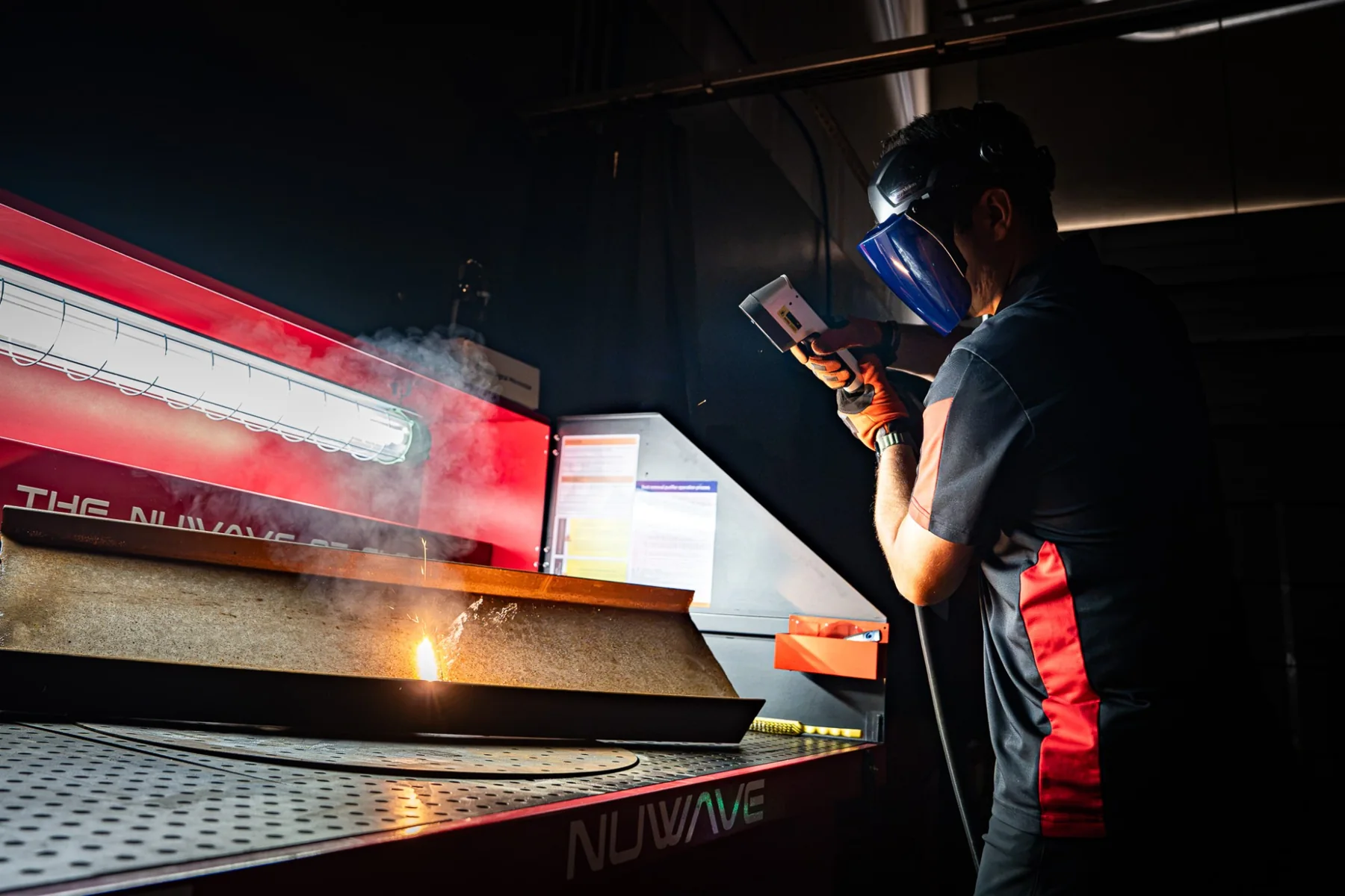 Operator laser cleaning rusted steel on a Nuwave cleaning table