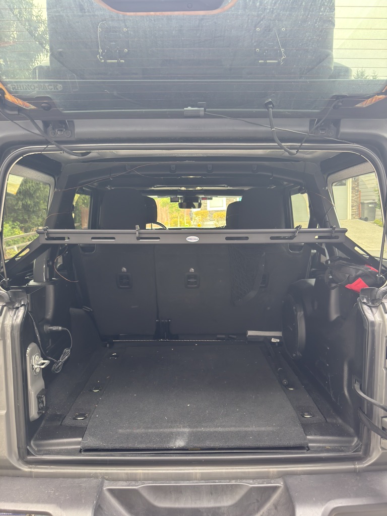 Open Jeep cargo interior showing crossbar storage and organized gear space