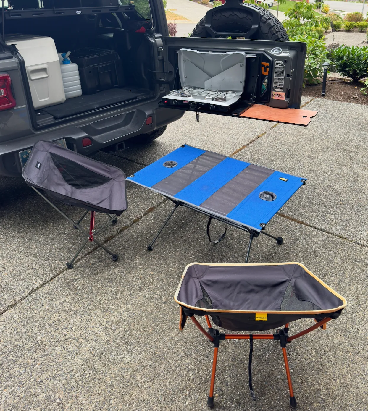 Two foldable camping chairs and table at a trail campsite