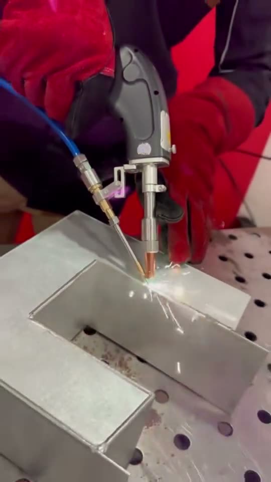 Welder using a handheld laser welder on a fabricated metal part