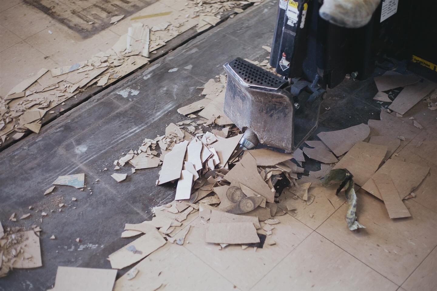 Tile debris cleared back to expose the bare concrete slab under a commercial floor