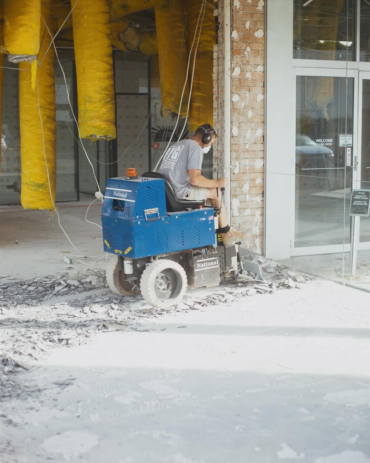 Blast Prep Grind operator on a ride-on scraper stripping tiles from a commercial shopfront floor
