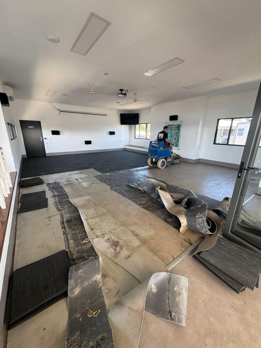 Commercial carpet removal exposing the concrete slab beneath