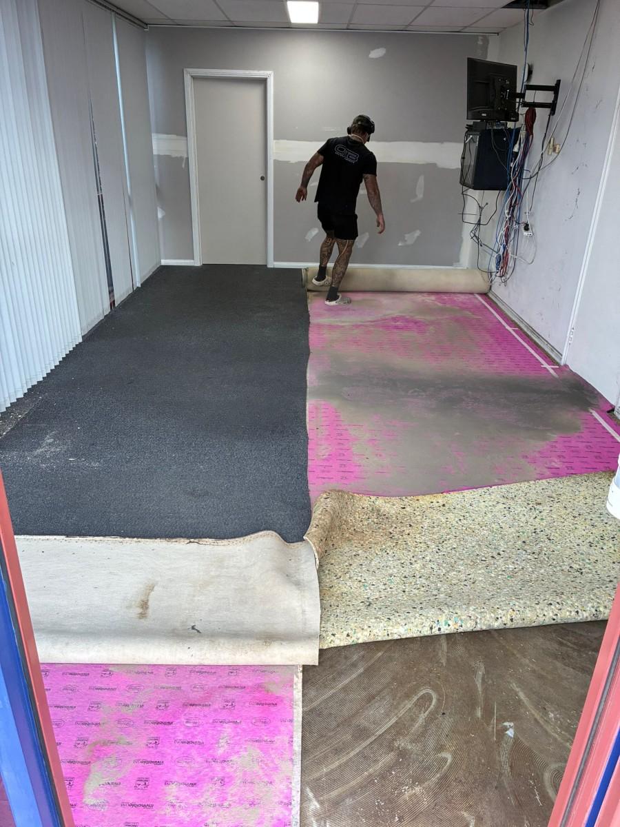 Commercial carpet removal in progress on a concrete slab