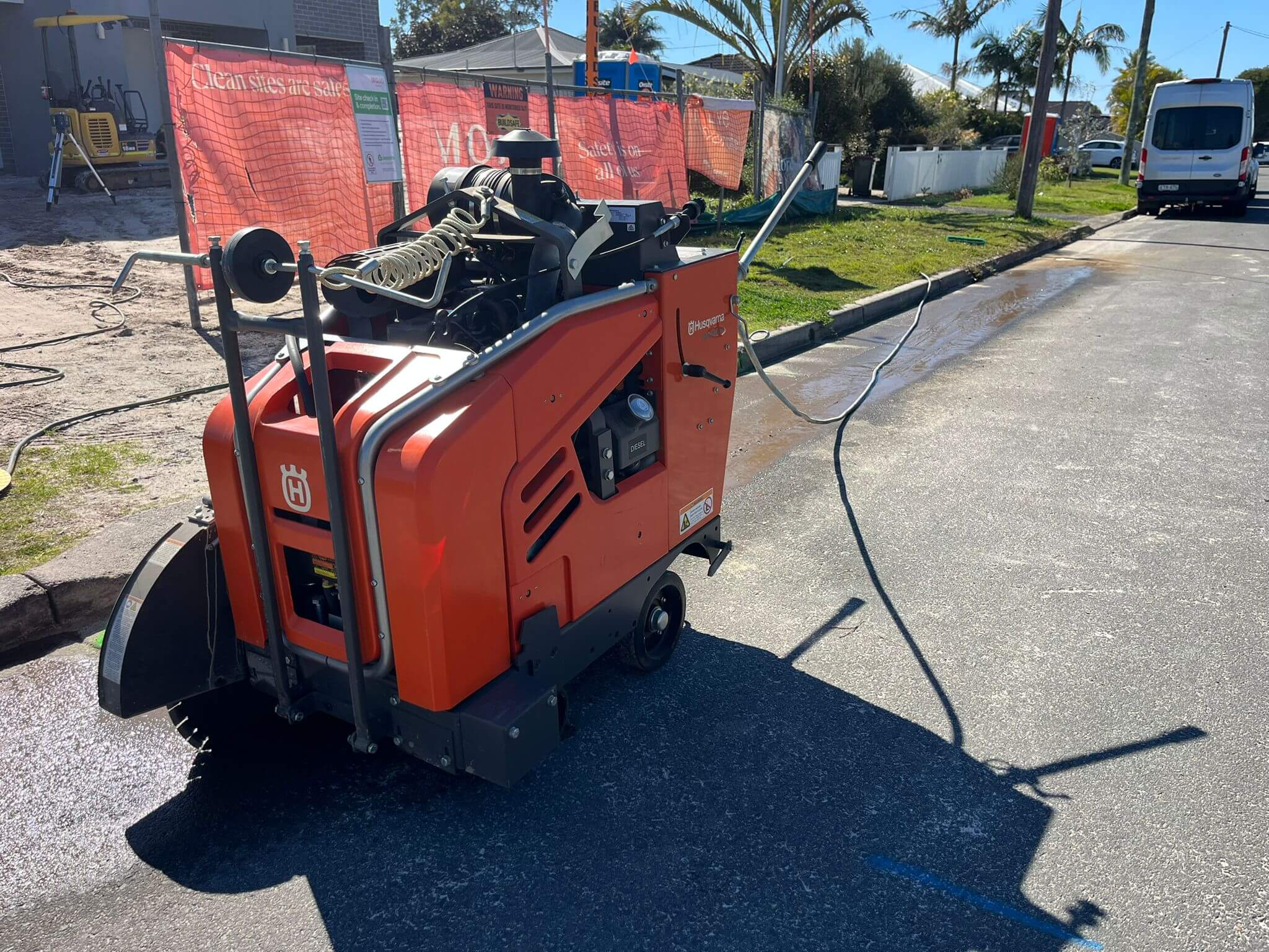 Ride-on road saw cutting a street surface in Newcastle