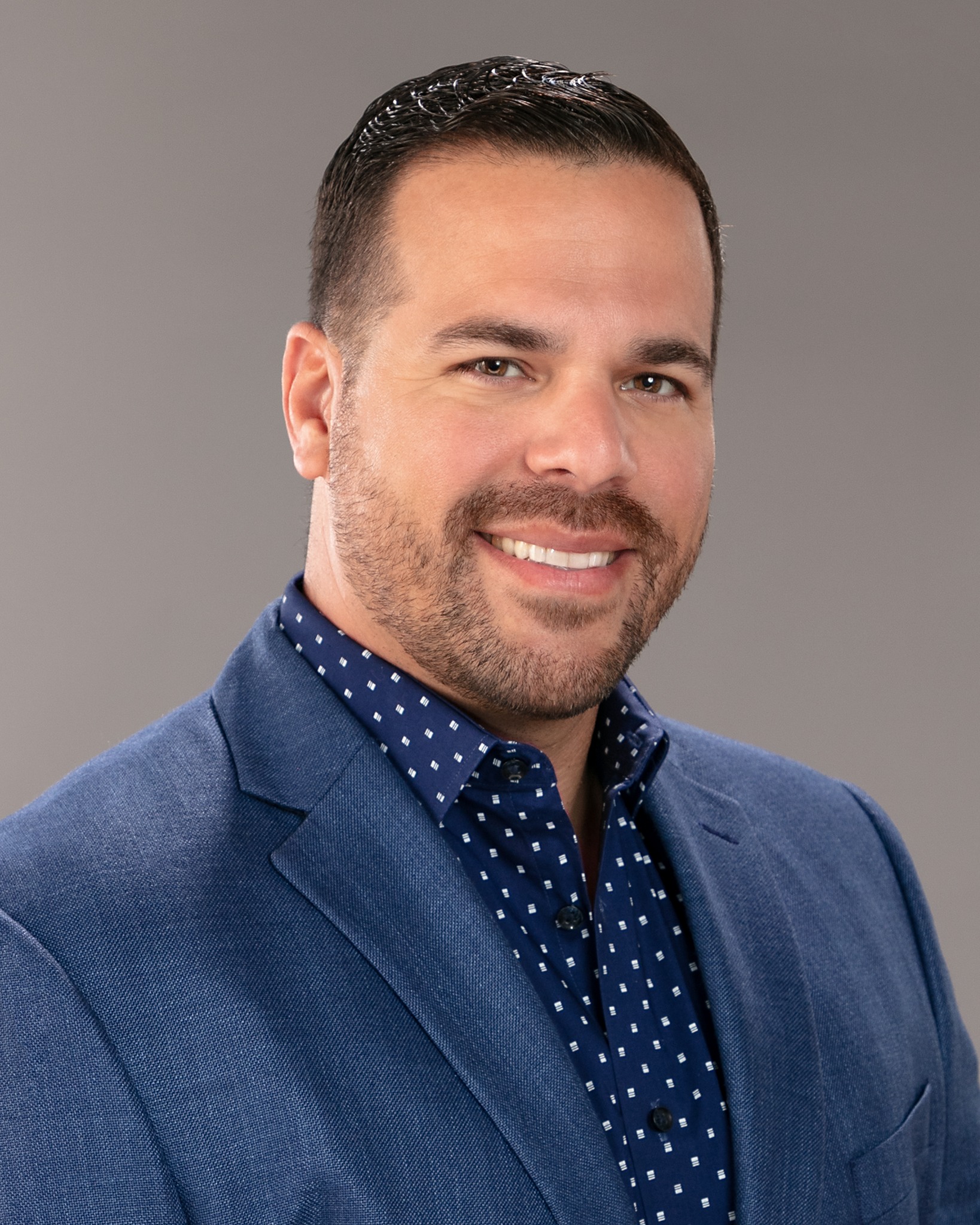Howard Sanchez, founder of Coravena, smiling in a navy blazer