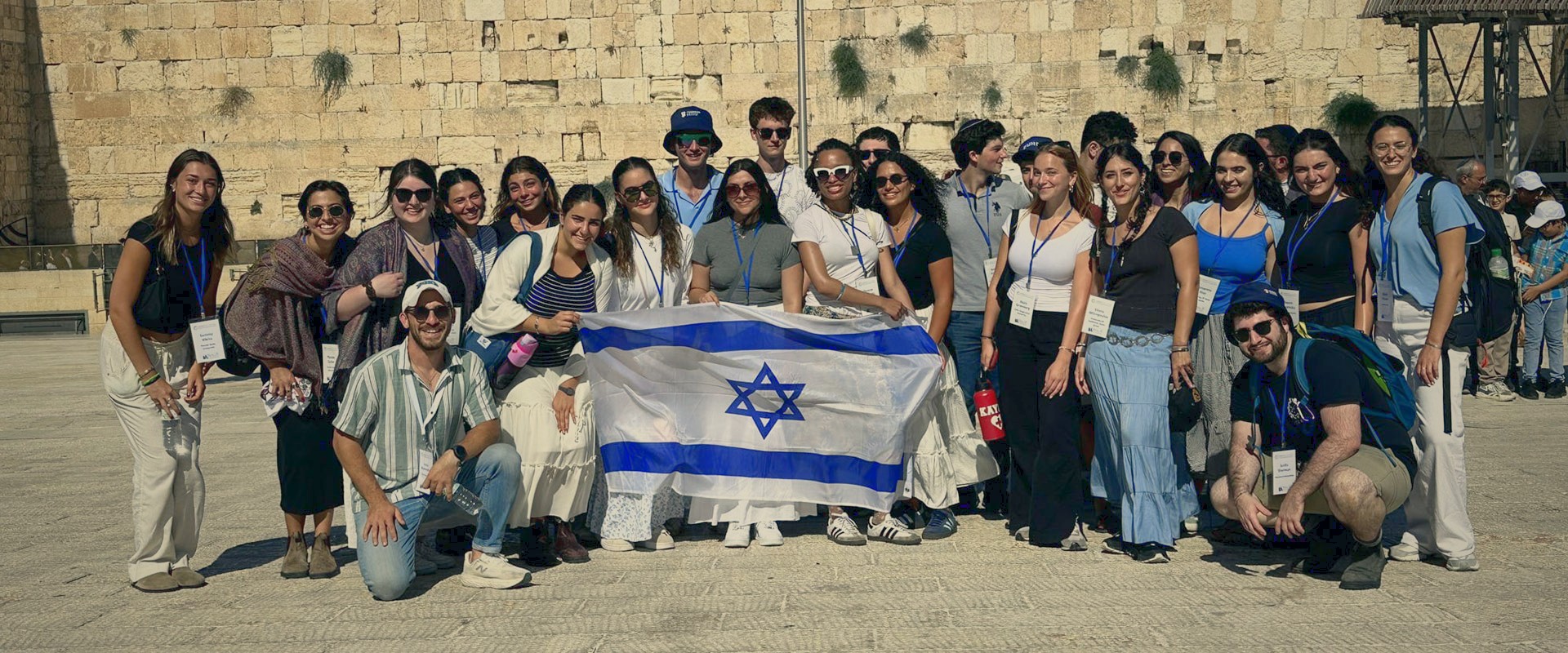 Student leaders hold an Israeli flag at the Western Wall.