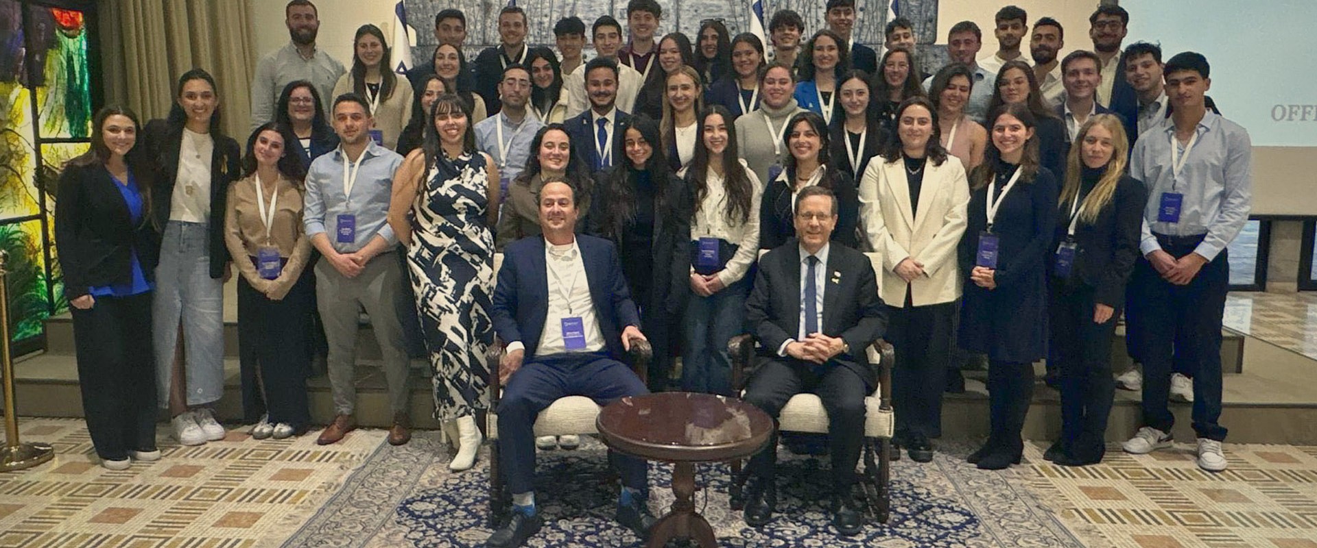 Delegation members and community leaders gather for a group photo with President Herzog.