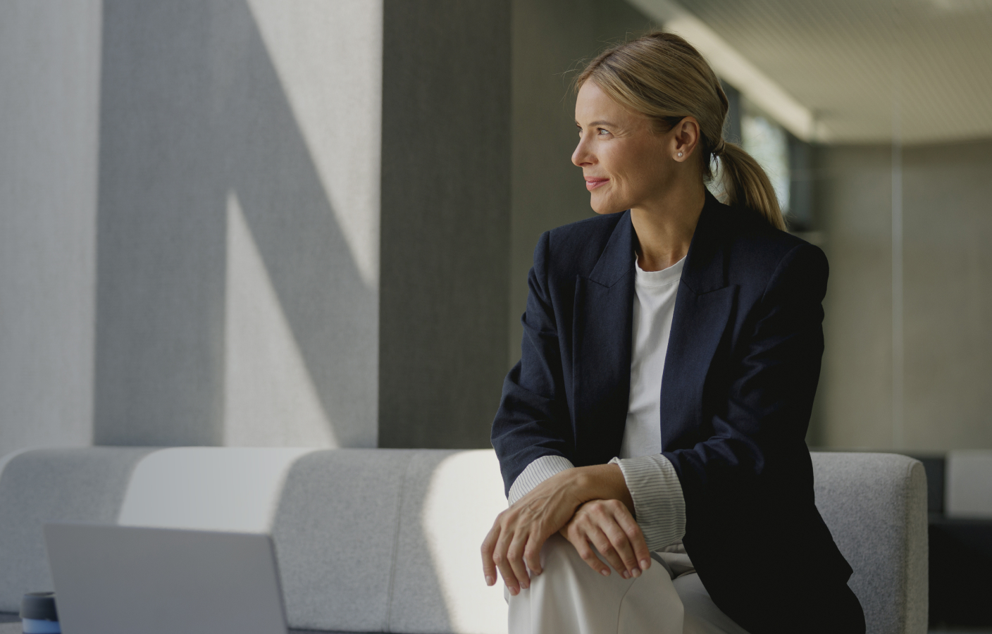 Businesswoman seated beside an office window.