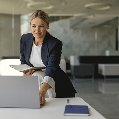 Businesswoman working on a laptop in an office.