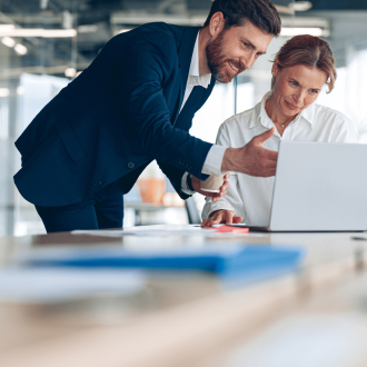 Two business professionals working together on a laptop.