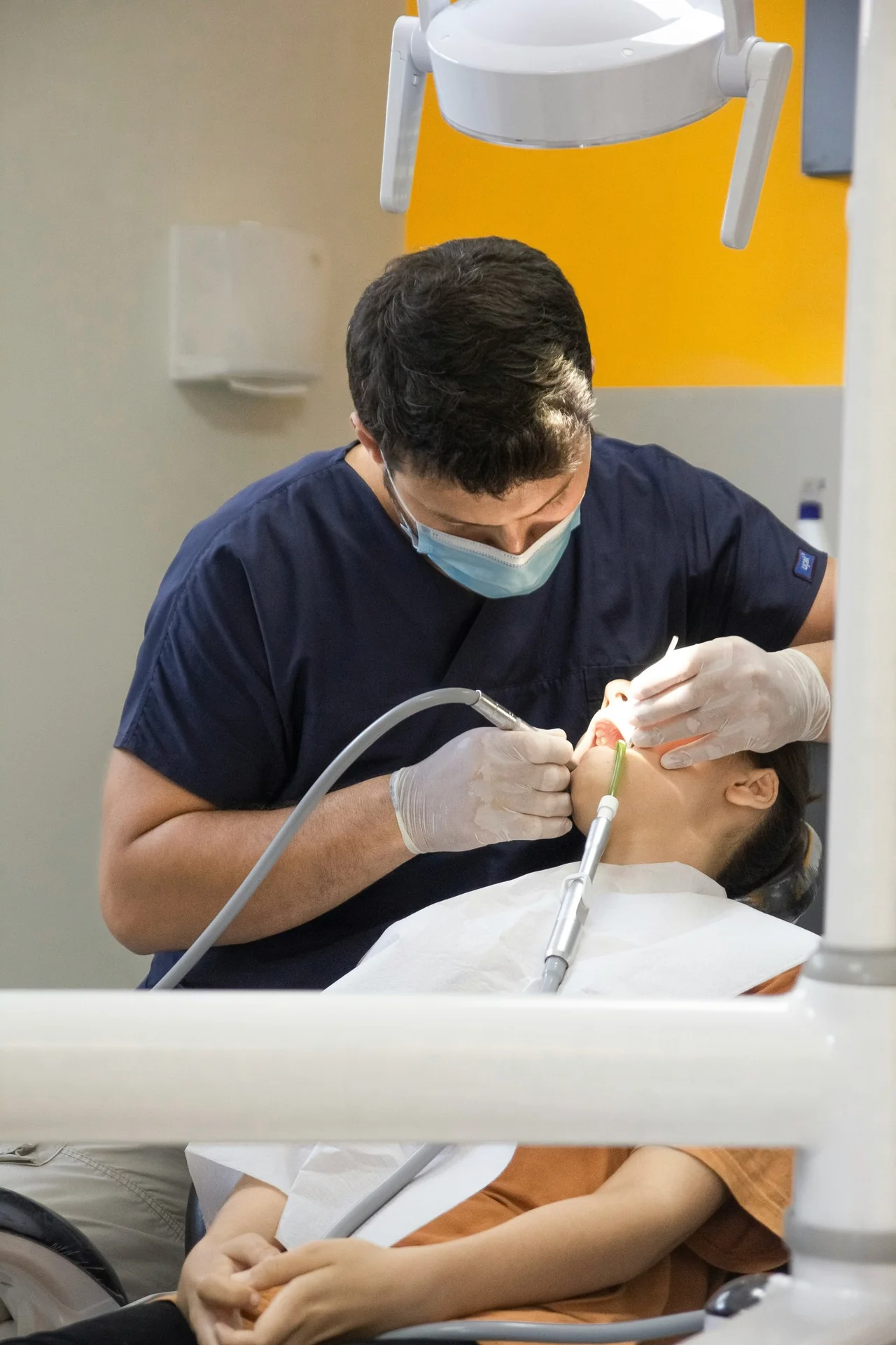 A dentist treats a patient in the dental chair