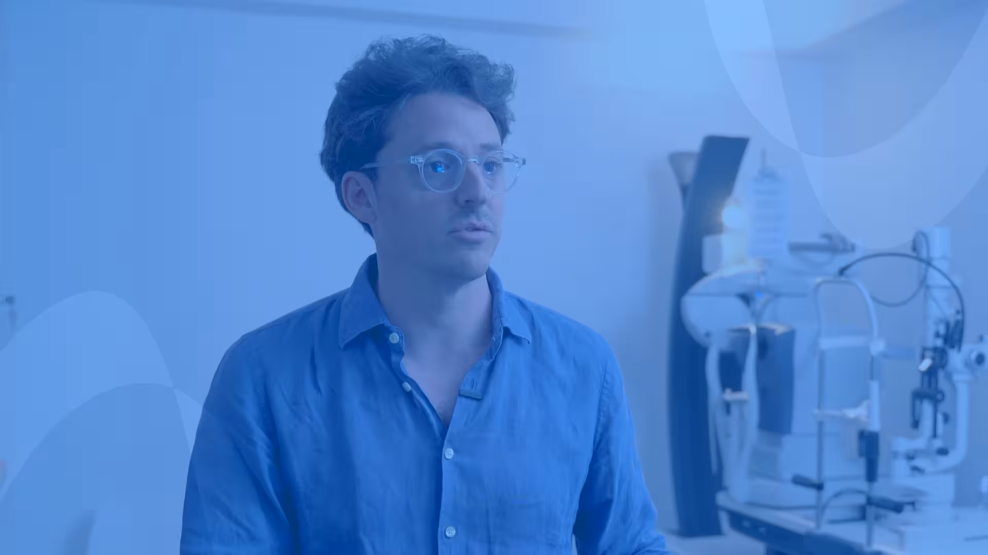 Retinax team member in an ophthalmology consulting room with eye exam equipment