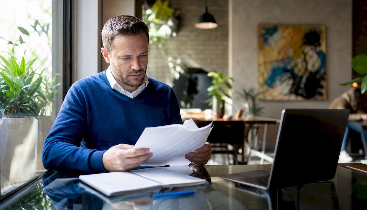 Hands sorting financial reports on office desk