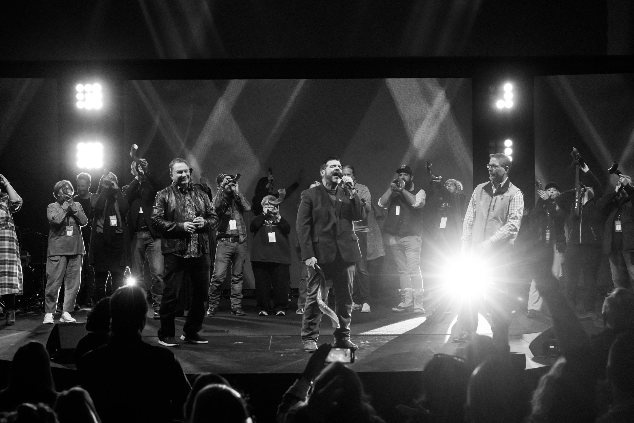 A full stage of musicians in bright concert light