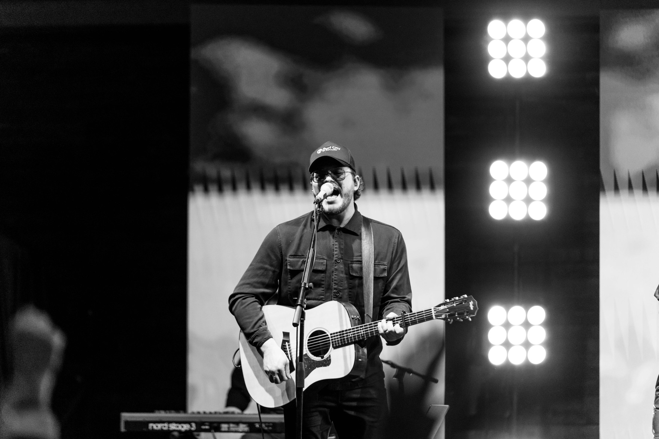 A guitarist singing into a microphone