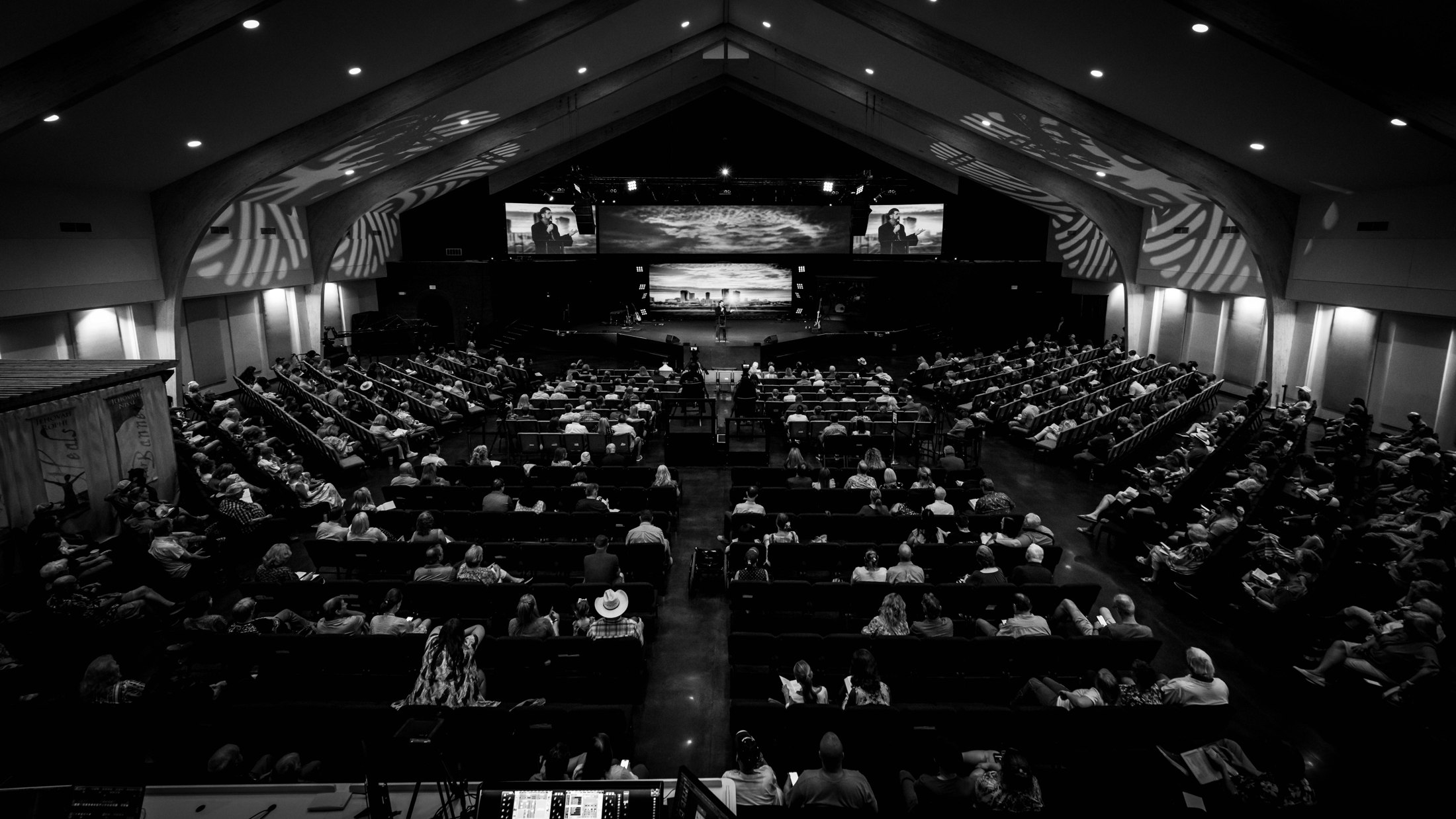 A wide black-and-white photograph of the congregation and stage