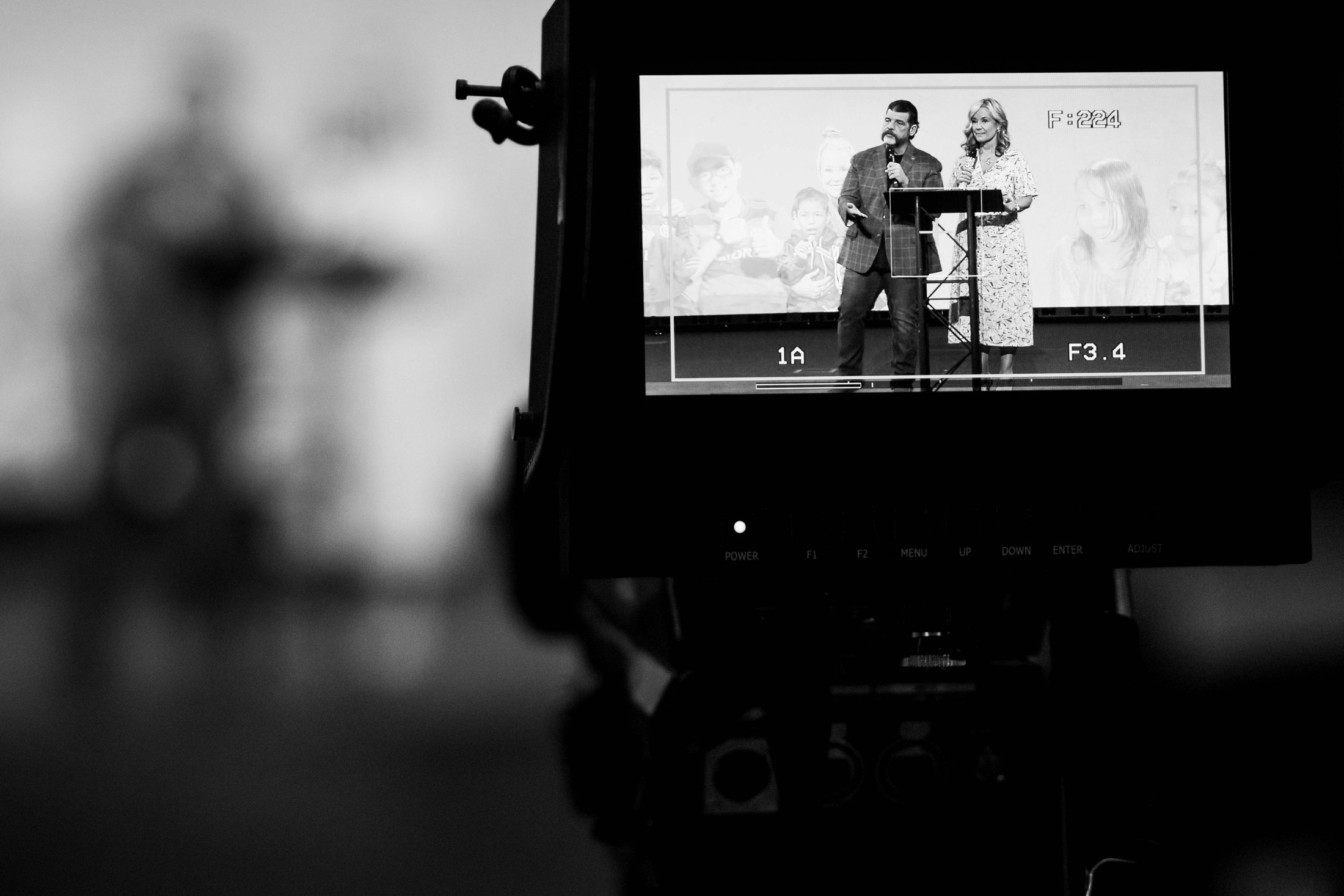 A video camera monitor framing two speakers