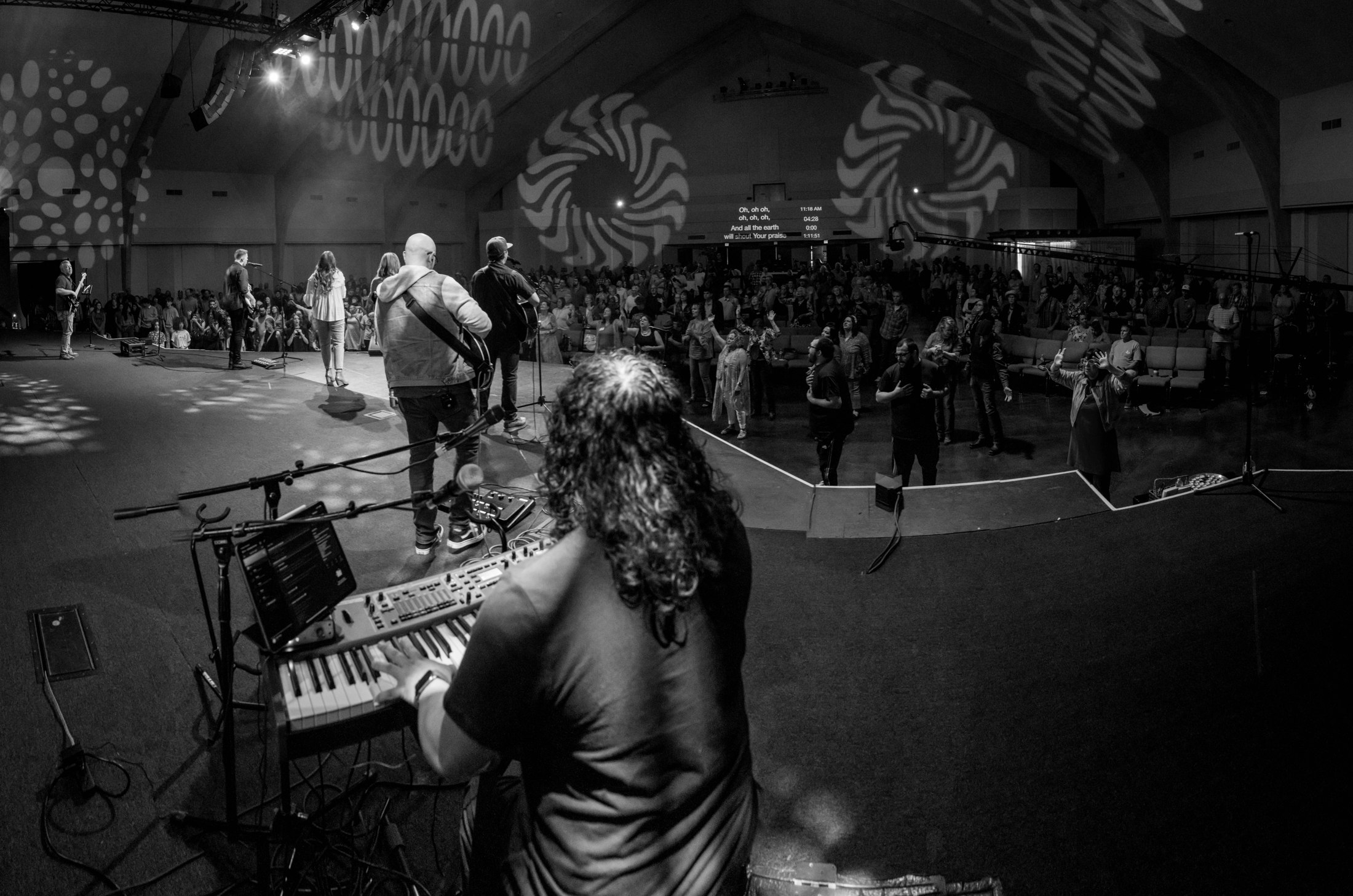 The room photographed from behind a keyboard player