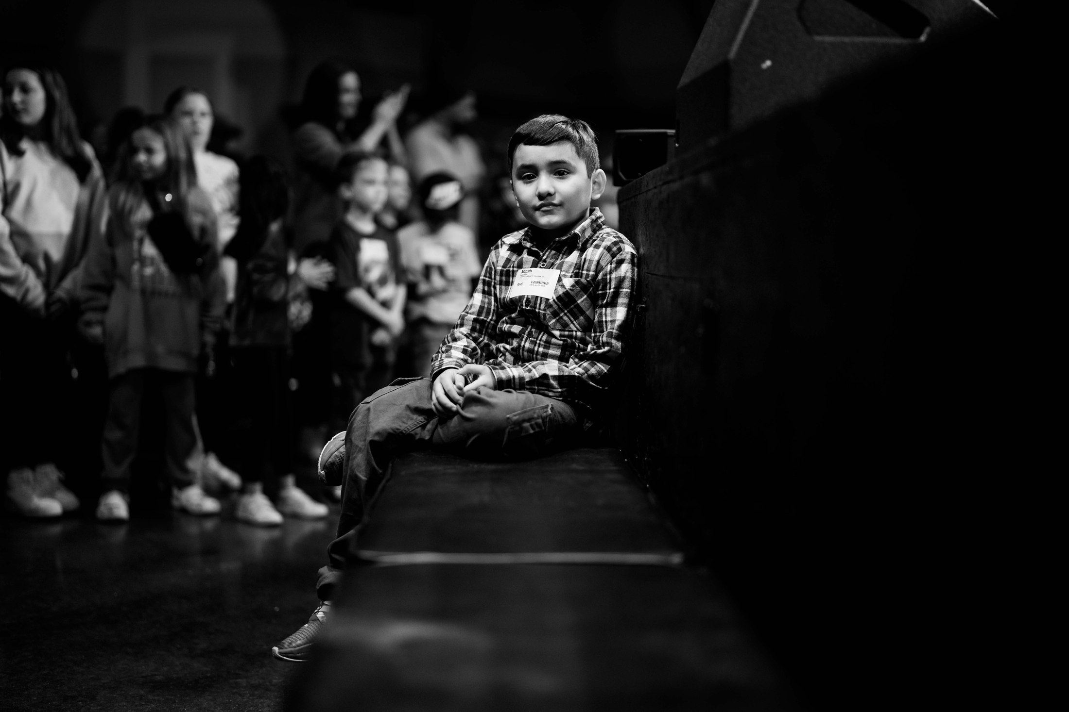 A child seated among the congregation, photographed in black and white