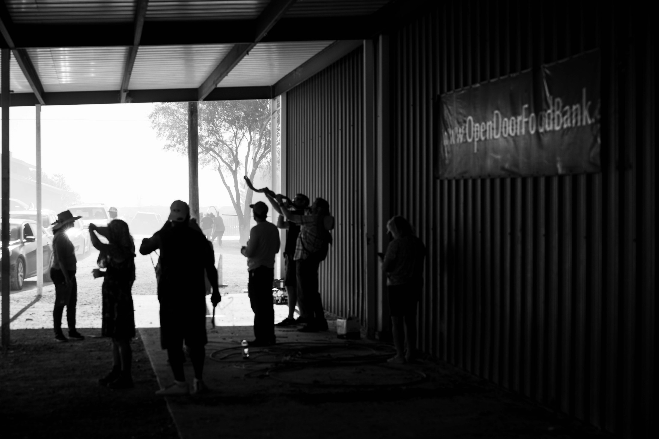 People gathered in an open-sided event space, photographed in black and white