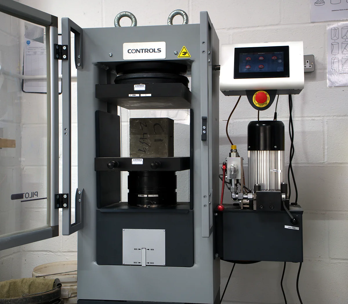 Compression testing machine with its door open in the Hixtra laboratory