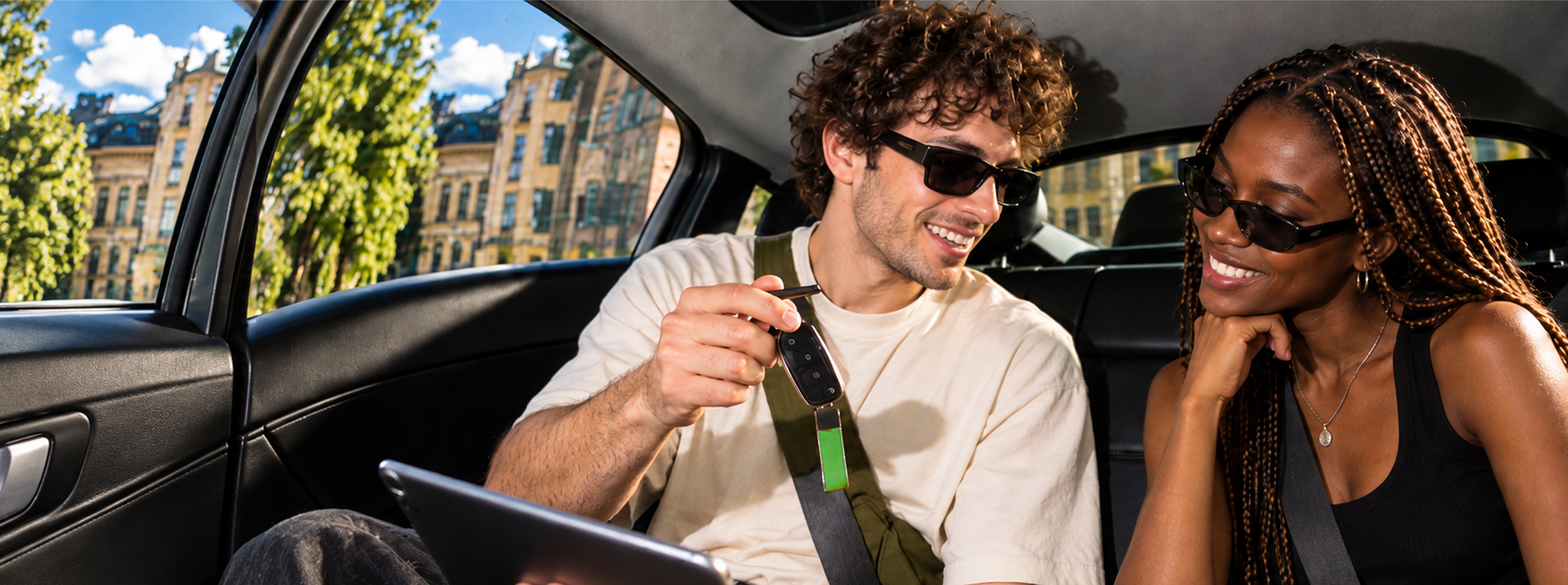 Jovens no banco traseiro a analisar carros num portátil