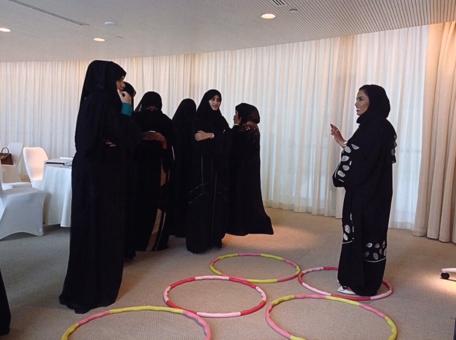 A training group standing beside six hula hoops arranged on the floor as a physical Six Circles exercise.