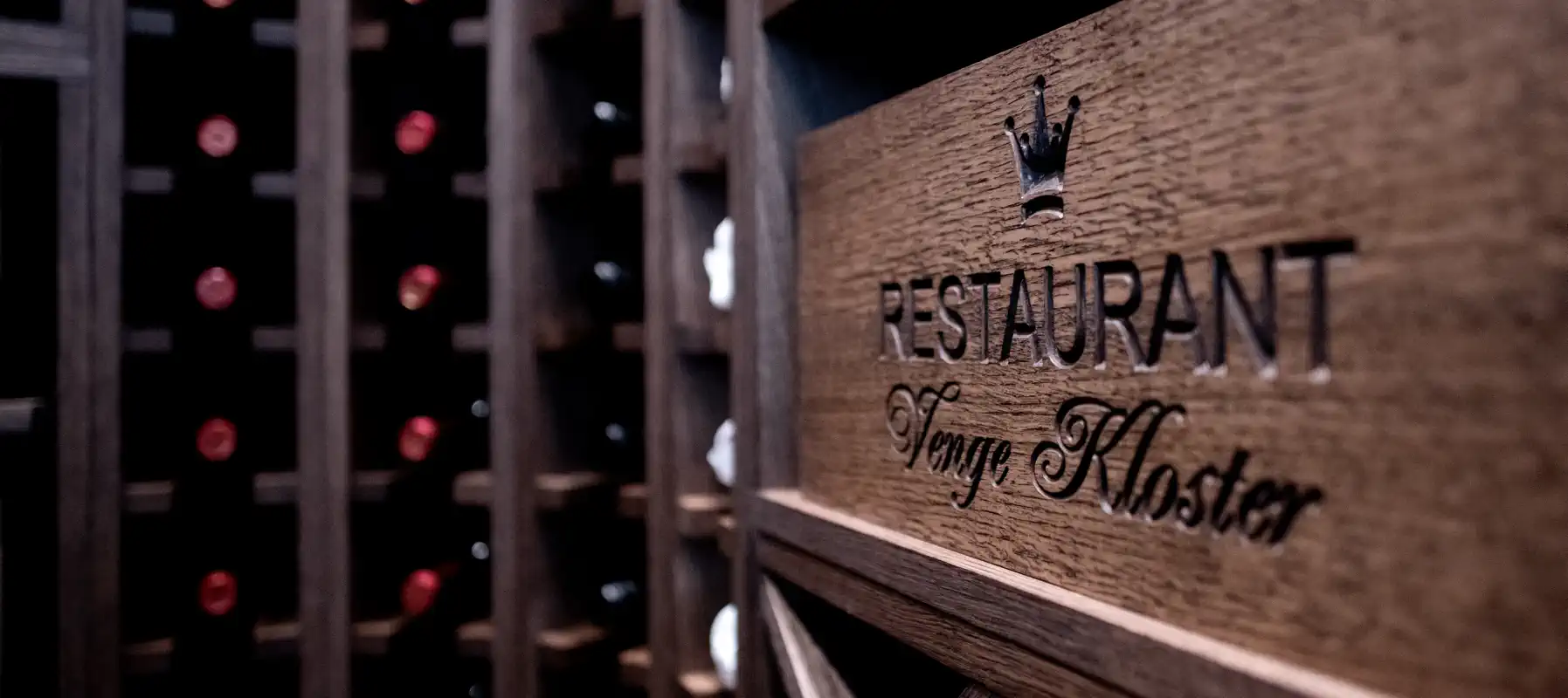 Restaurant Venge Klosters navn og krone på en trævinkasse.