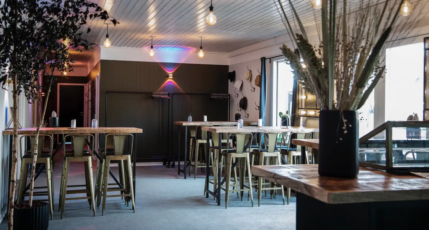 Musikbaren på Gammel Høver med høje borde og farvet belysning.