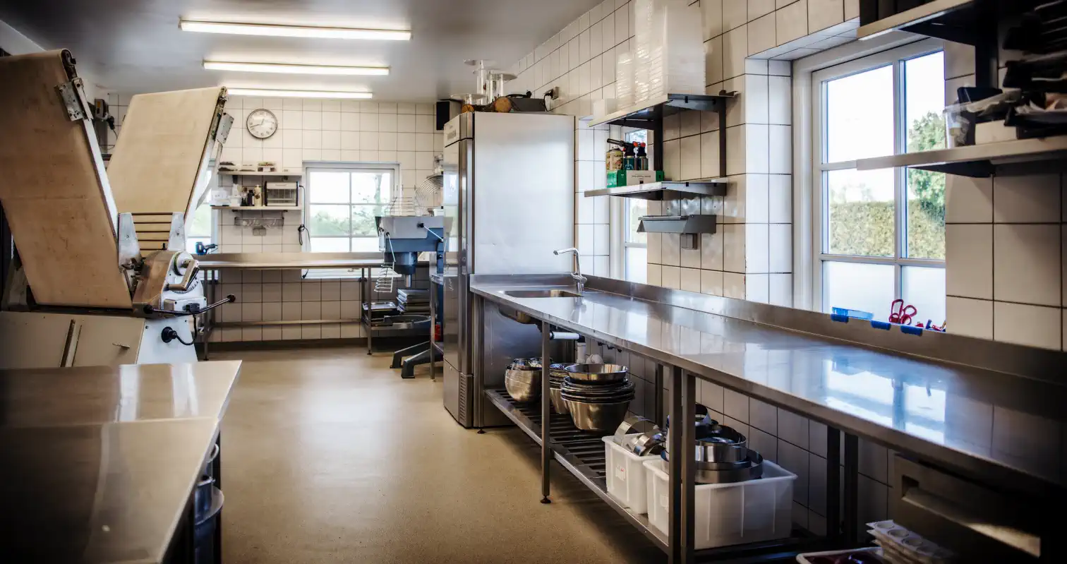 Restaurantens konditori med arbejdsborde og professionelt køkkenudstyr.