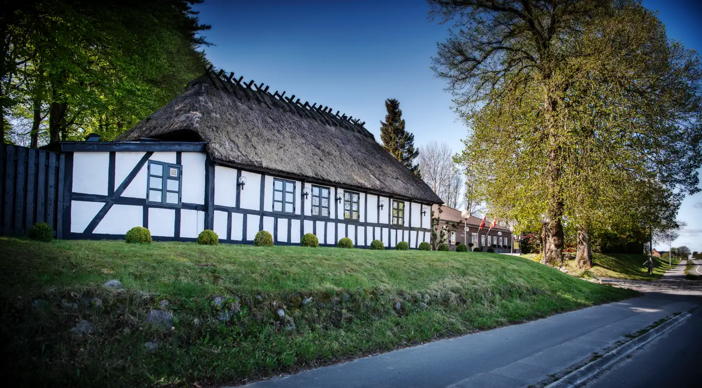 Skovhuset ved Lilleringskov, et bindingsværkshus med stråtag ved skoven.