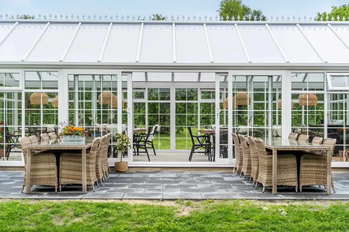 Orangeriet i haven på Venge Kloster med havemøbler foran glasfacaden.