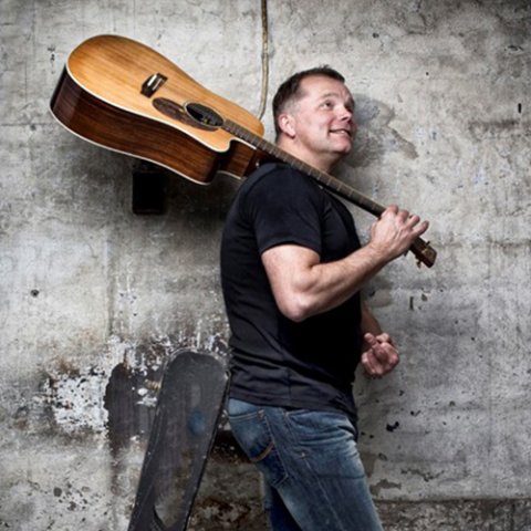 Per Andersen med en guitar over skulderen.