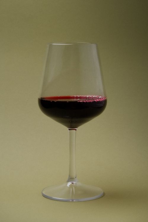 Clarity Wine Glass with Wine on Light Green Background