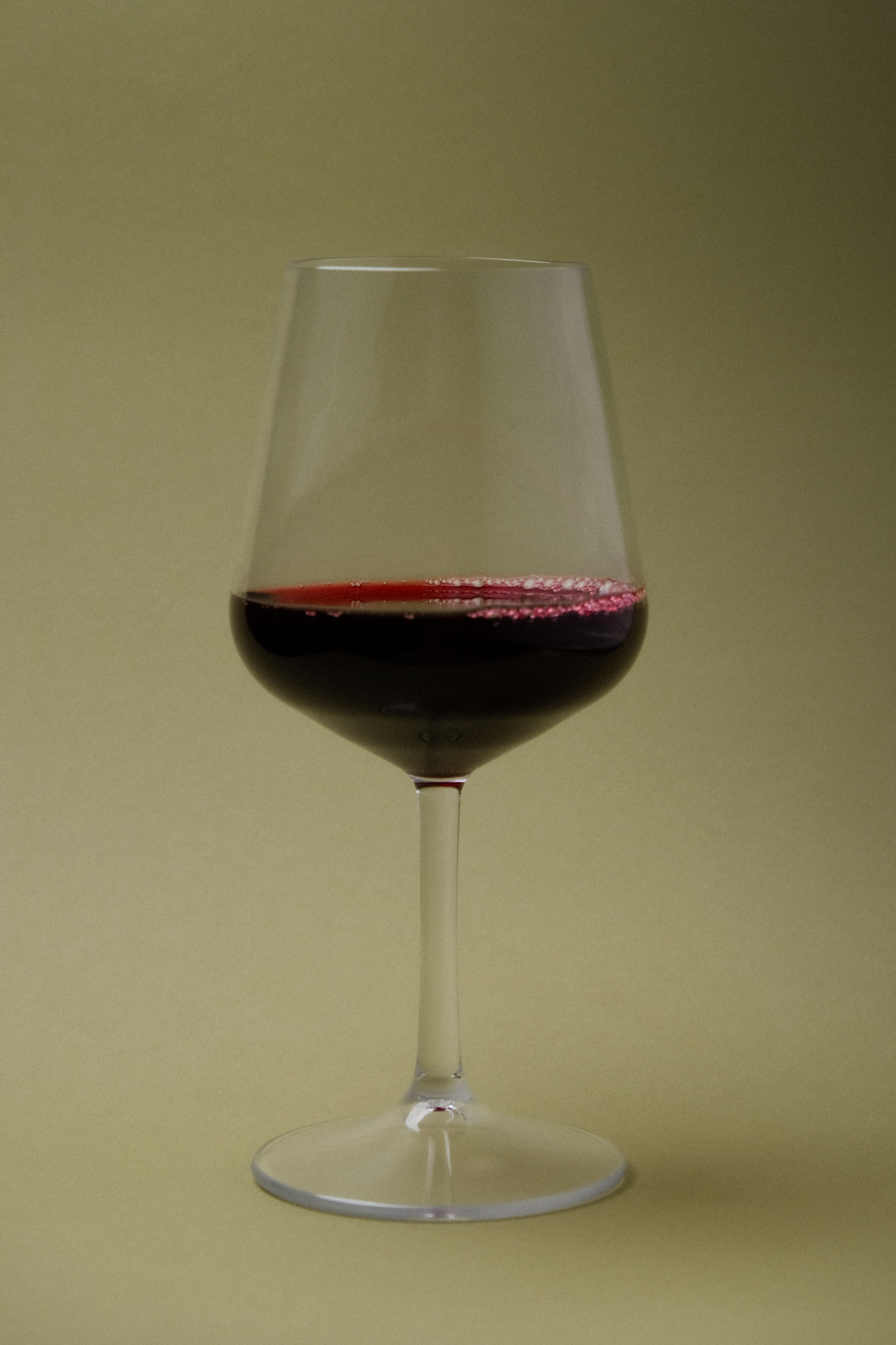 Clarity Wine Glass with Wine on Light Green Background
