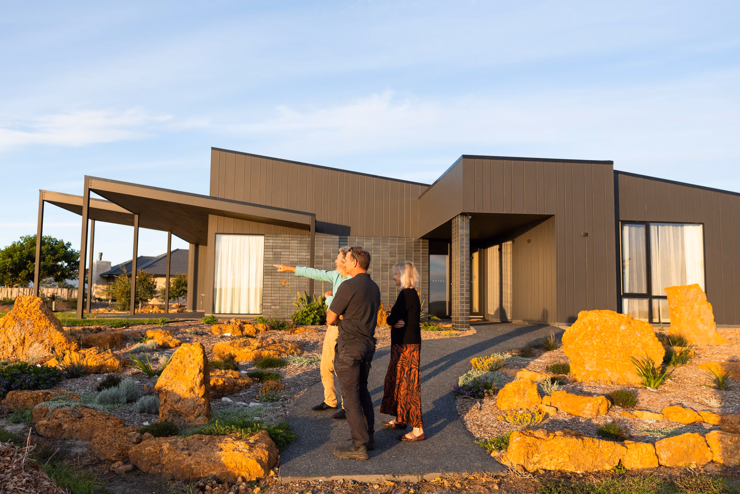 Michael Smyth walking homeowners through the garden of their finished home in Denmark, WA