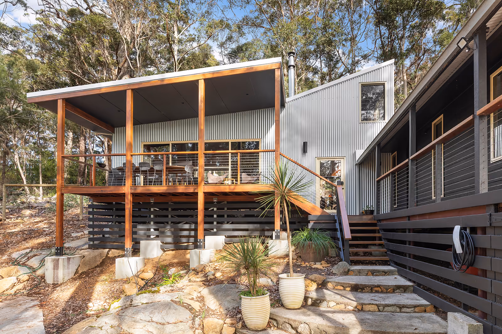 Award-winning pole home deck raised on piers over a rocky bush slope in Denmark, WA