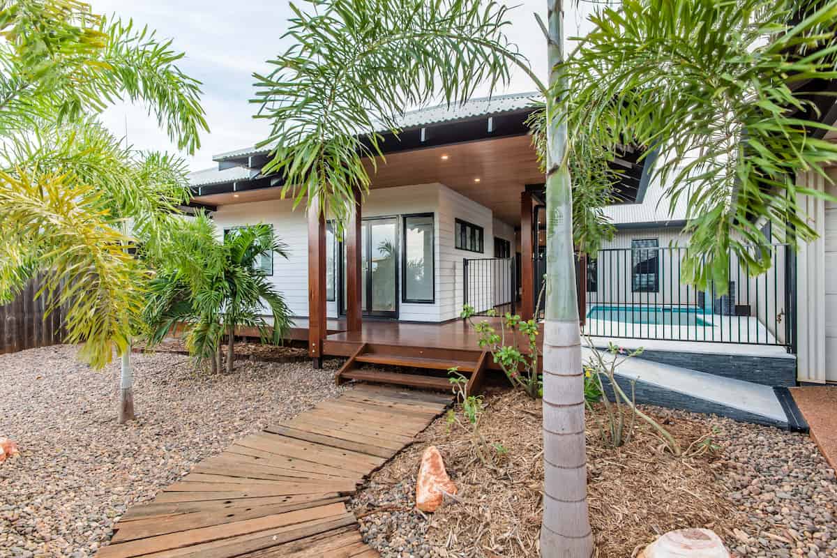 Rear garden, deck and pool fence framed by palms at a northern WA home built by Michael Smyth