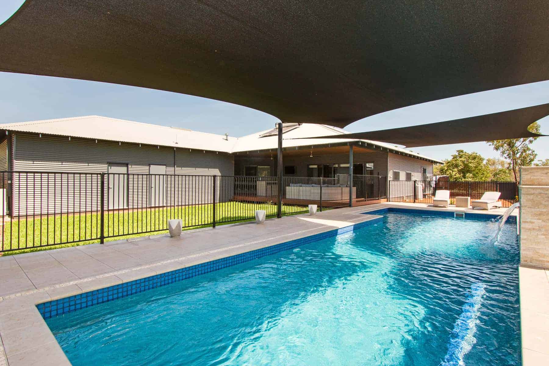 Backyard pool under shade sails behind a home built by Michael Smyth in northern WA