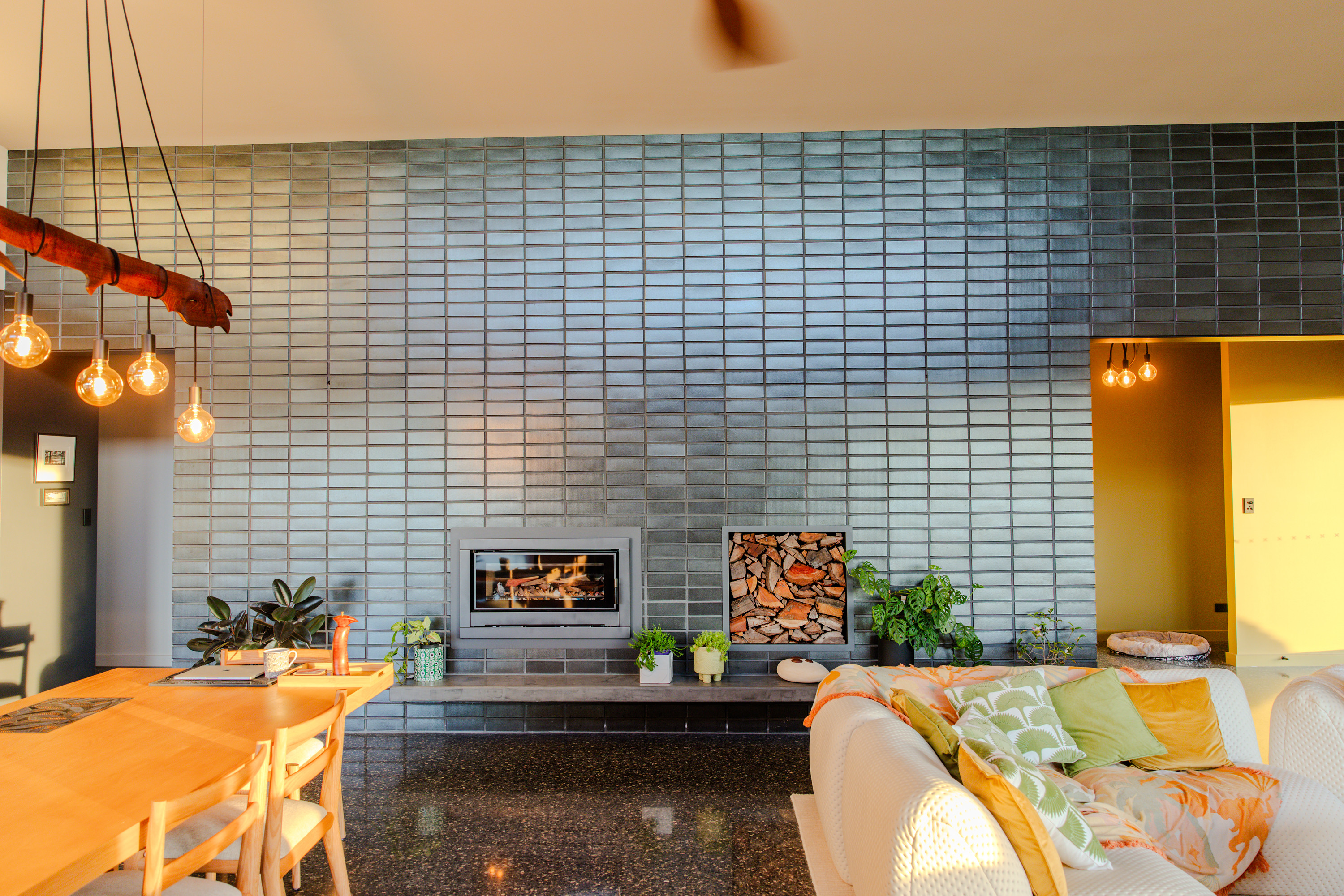 Wood heater glowing in a glazed brick wall at dusk in a custom home in Denmark, WA