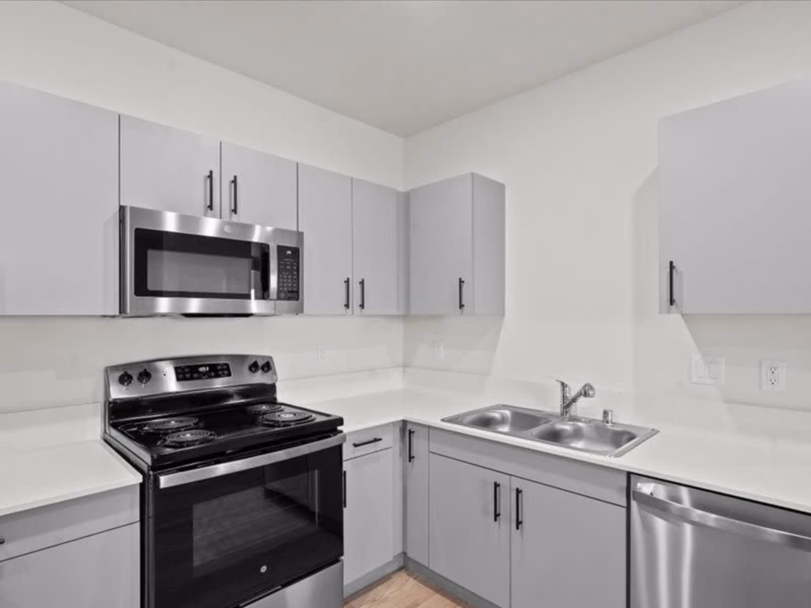Large kitchen with gray cabinets and stainless steel appliances