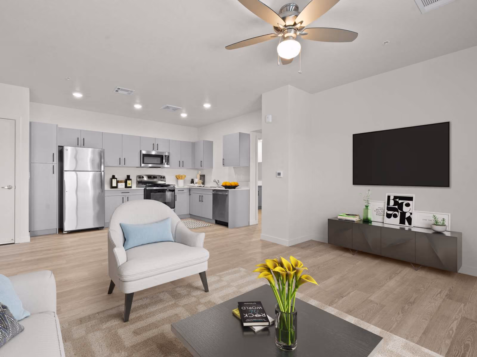 Virtually staged living area with sofa, tv, and coffee table and view of kitchen 