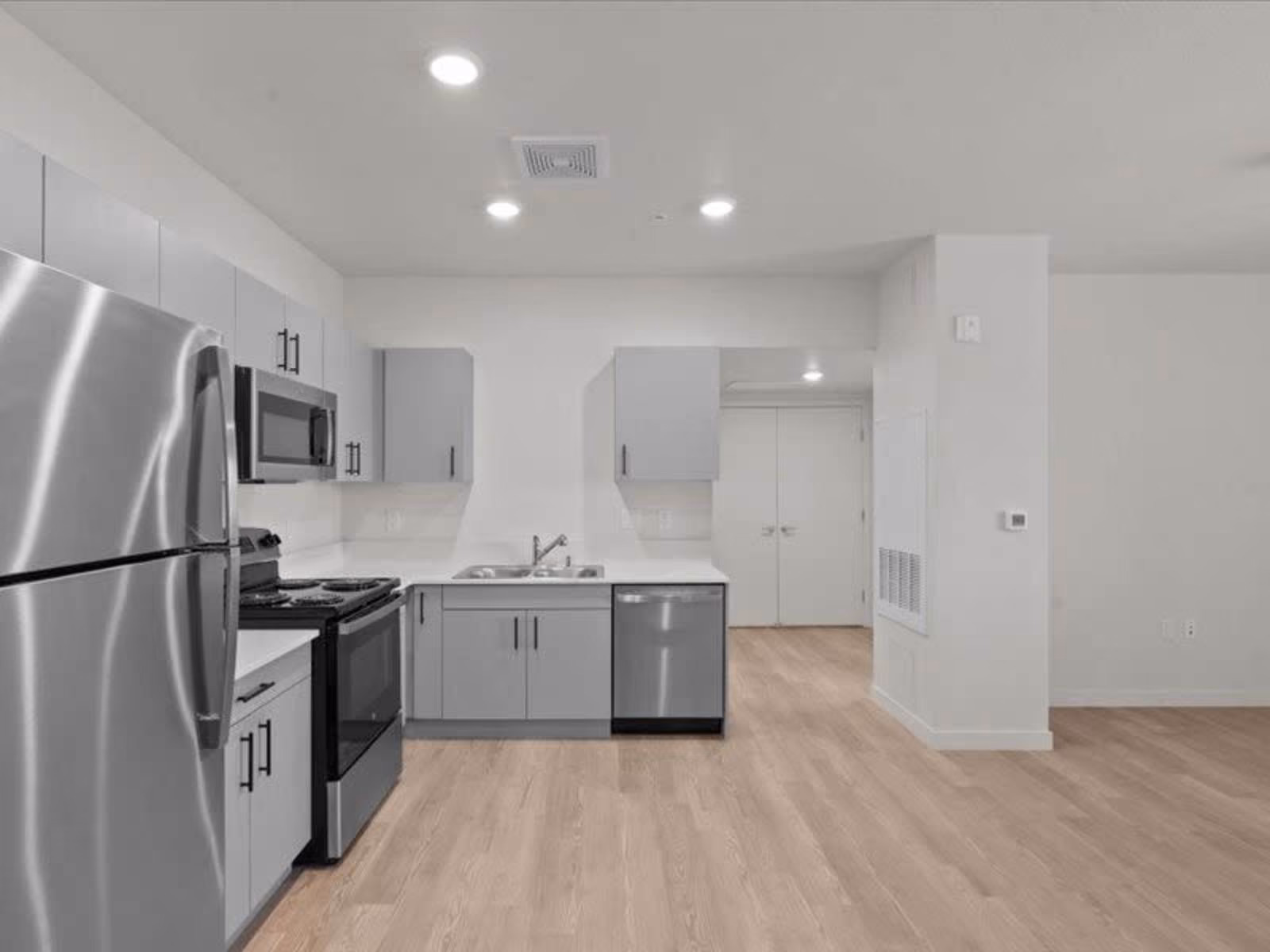 Large kitchen with gray cabinets and stainless steel appliances