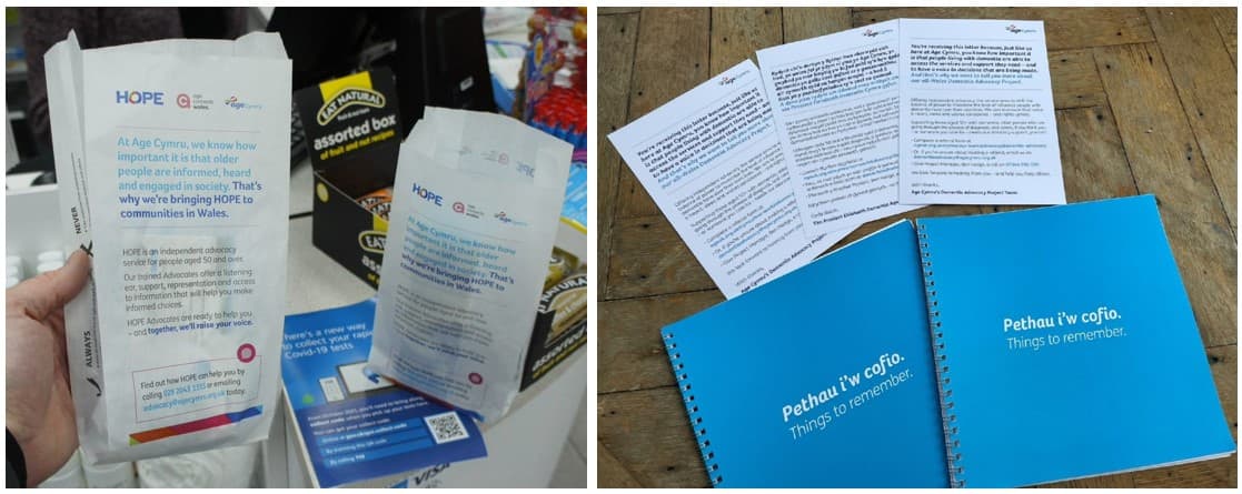 Age Cymru HOPE dementia advocacy pharmacy bags on a pharmacy counter, alongside blue 'Pethau i'w cofio - Things to remember' booklets