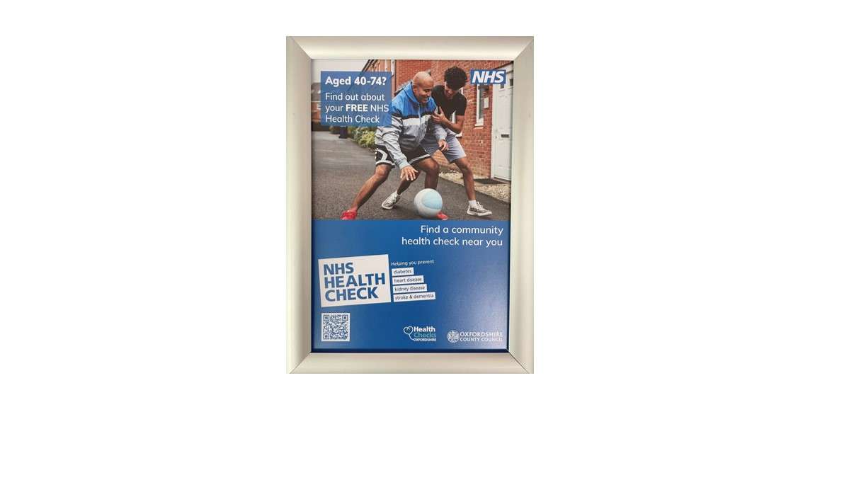 Framed Oxfordshire County Council NHS Health Check poster for people aged 40 to 74, showing two people playing basketball