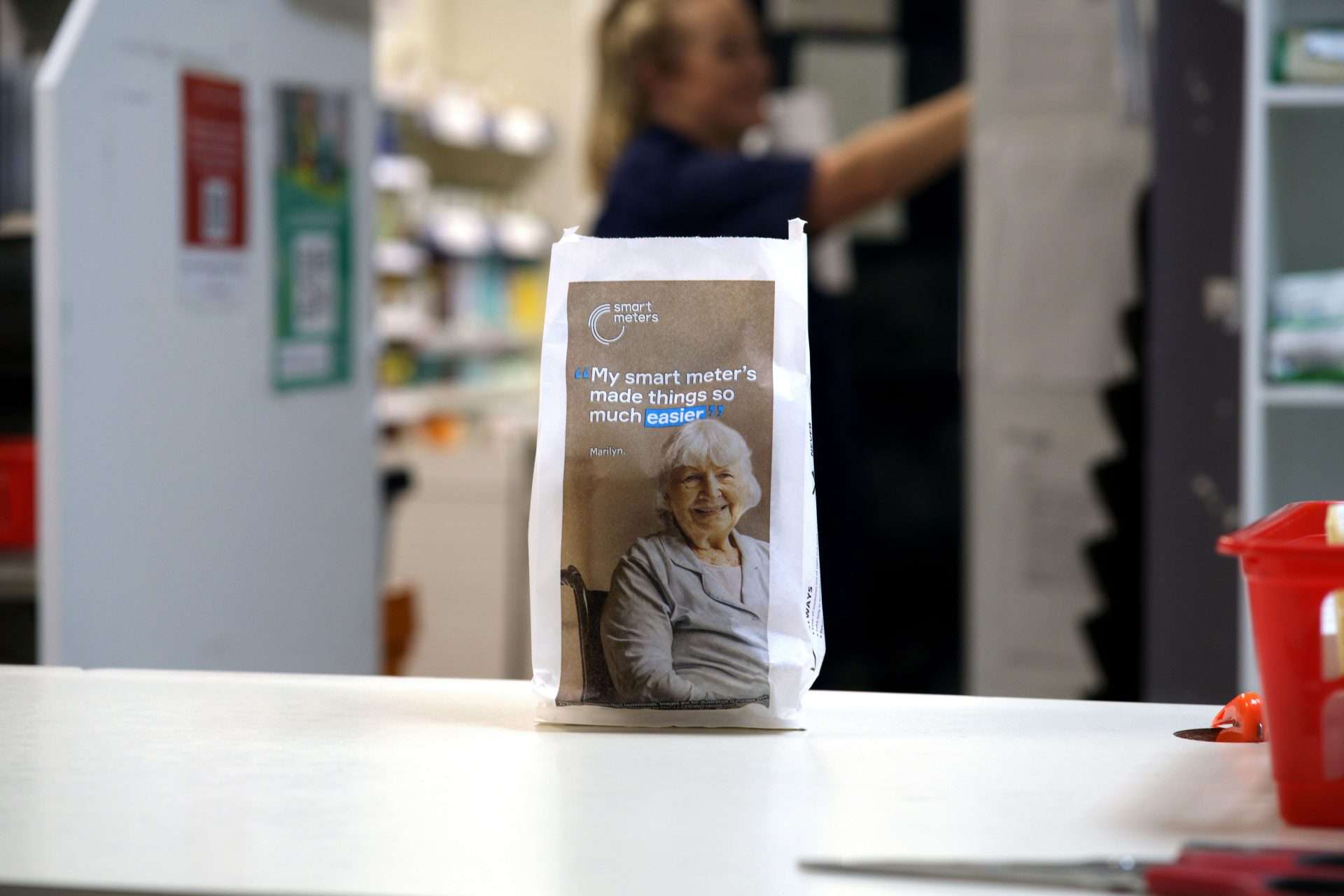 Smart Energy pharmacy bag featuring an older woman and the quote 'My smart meter's made things so much easier', on a pharmacy counter