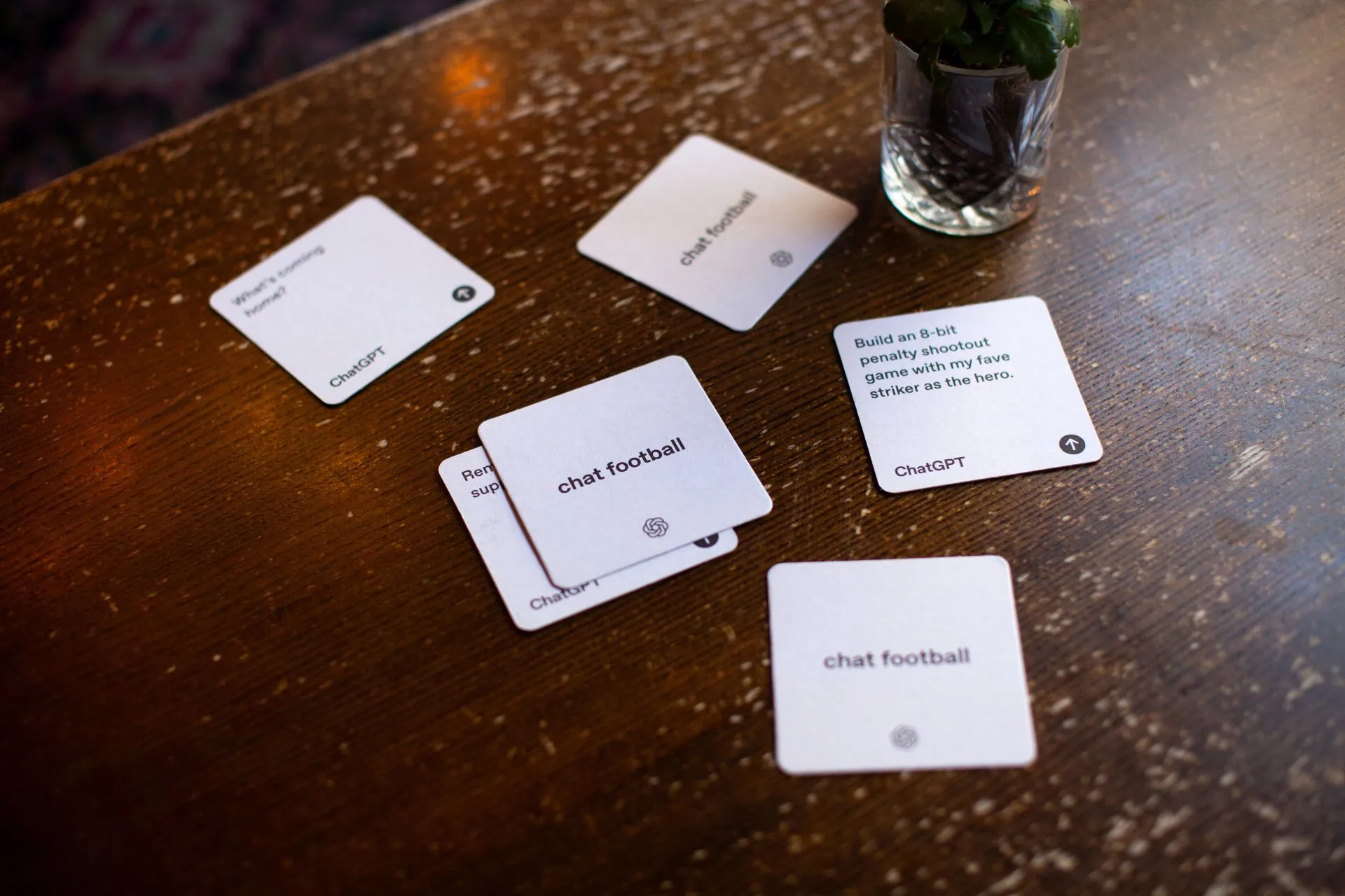 ChatGPT 'chat football' beer mats scattered on a wooden pub table