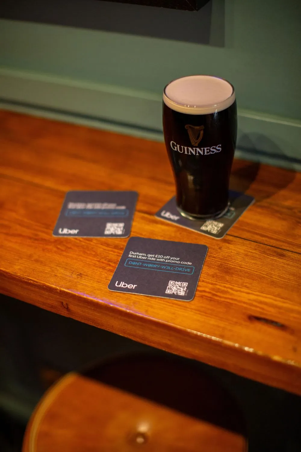 Uber Durham promo code beer mats on a wooden pub bar beside a pint of Guinness