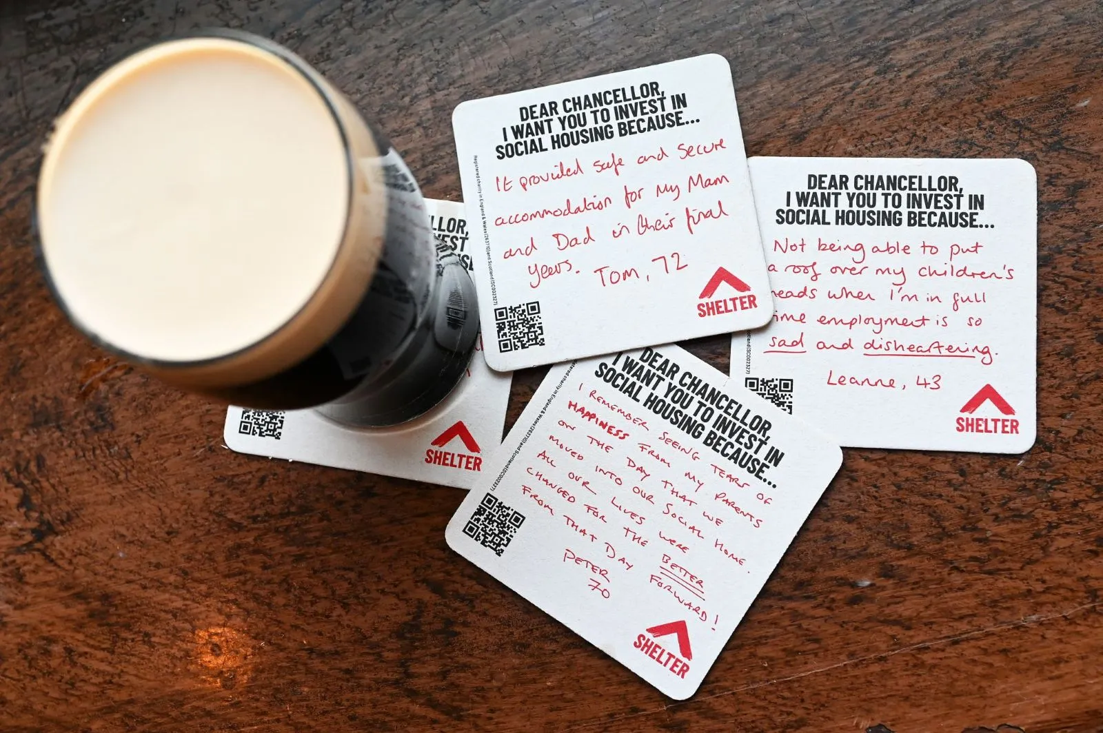 Shelter 'Dear Chancellor, I want you to invest in social housing' handwritten beer mats beside a pint of stout